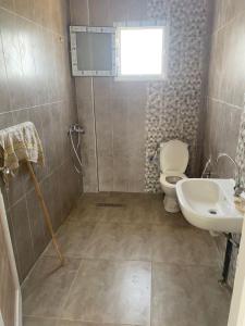 a bathroom with a toilet and a sink at résidence Ferjani hechmi in Rafrāf
