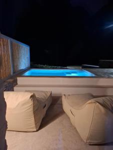 una piscina con cama y almohadas en una habitación en Venue Villas - Folegandros, en Áno Meriá