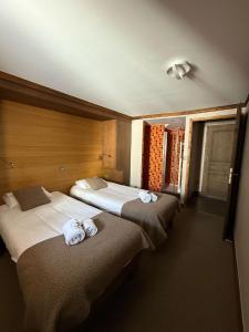 two beds in a hotel room with towels on them at Résidence Montana Caron by Village Montana in Val Thorens