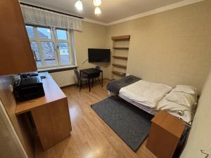 a small room with a bed and a desk and a television at Apartamenty JN Poznań Rzeczna 4 in Poznań