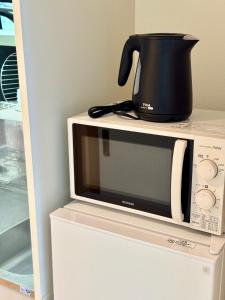a microwave oven with a pot on top of it at セレーナ南福岡 in Fukuoka