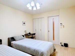 a bedroom with two beds and a chandelier at セレーナ南福岡 in Fukuoka