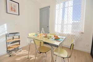a dining room with a glass table and chairs at La Campus Douillet in Saint-Étienne