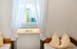 een kamer met een raam met witte gordijnen en een radiator bij U13 Eg in Marienfelde