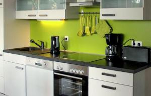 een keuken met groene muren en een fornuis bovenste oven bij K104 Eg in Marienfelde