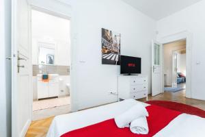 a white bedroom with a red blanket on a bed at 2BDR Old Town Square Apartments w Fast Wi-Fi in Prague