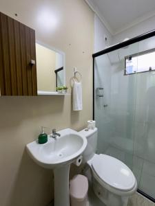 a bathroom with a toilet and a sink and a shower at Espaçosa casa com WI-FI Perto do Aroporto - Conforto e Praticidade in Joinville
