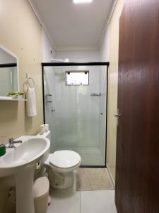 a bathroom with a shower and a toilet and a sink at Espaçosa casa com WI-FI Perto do Aroporto - Conforto e Praticidade in Joinville +31 photos