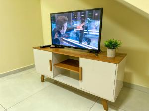 a flat screen tv sitting on top of a cabinet at Espaçosa casa com WI-FI Perto do Aroporto - Conforto e Praticidade in Joinville