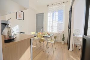 a kitchen with a table and chairs in a room at La Campus Douillet in Saint-Étienne