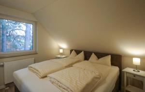 een slaapkamer met een bed met twee kussens en een raam bij K108 Og in Marienfelde