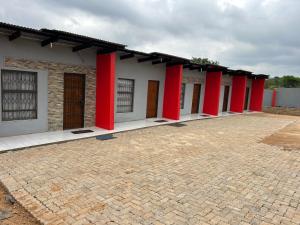 eine Reihe roter Säulen an einem Gebäude in der Unterkunft Lakeboutiquehotel empire new in Thohoyandou