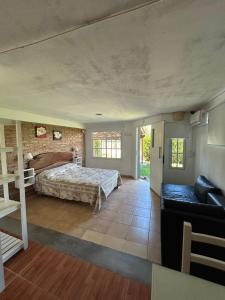 a bedroom with a bed and a couch in a room at Agosto 23 in Mina Clavero +16 photos