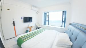 Un dormitorio con una cama y un televisor. en Zhangjiajie Qingfeng B&B West Station Branch, en Zhangjiajie