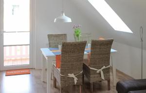 een eettafel met stoelen en een vaas met bloemen bij K104 Og in Marienfelde