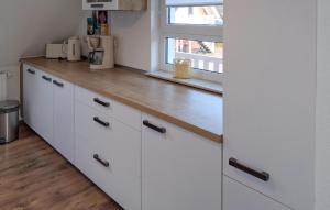 een keuken met witte kasten en een houten aanrechtblad bij K104 Og in Marienfelde +6 foto's