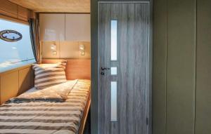 een kleine slaapkamer met een bed en een deur bij Haus Boot Sea Breeze in Marienfelde