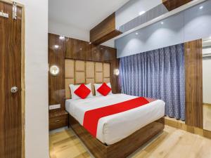 a bedroom with a large bed with red pillows at Super Hotel O bhanu Villa in Ahmedabad +21 photos