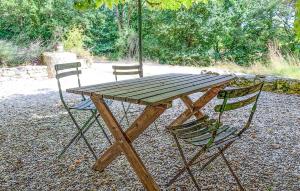 einem Picknicktisch aus Holz mit 2 Stühlen und einem Sonnenschirm in der Unterkunft Charmante Maison Avec Piscine in Monsac + 17 Fotos