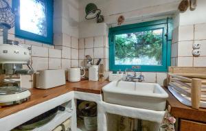 eine Küche mit Spüle und Fenster in der Unterkunft Charmante Maison Avec Piscine in Monsac