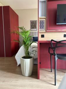 een plant in een witte pot in een kamer bij BetaSuites in Curitiba