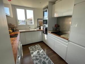 a kitchen with white cabinets and a kitchen rug at Elegant apartment Saint-Raphaël in La Celle-sous-Gouzon +6 photos