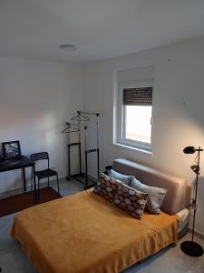 ein Schlafzimmer mit einem Bett, einem Fenster und einem Schreibtisch in der Unterkunft Boki in Belgrad