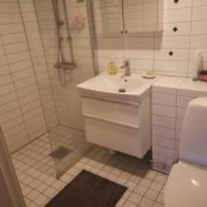a bathroom with a sink and a shower and a toilet at One Large Room with 3 single beds in Gothenburg