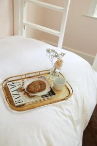 a tray with a cake and a plate on a bed at Bosch Huse Rosé - Zomer in Savannah