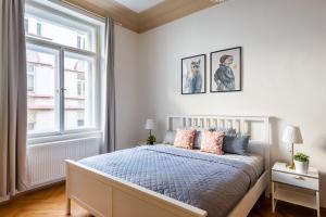 a white bedroom with a bed and a window at 2BDR Old Town Square Apartments w Fast Wi-Fi in Prague