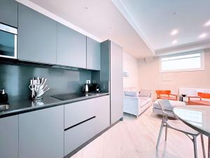 a kitchen with white and black cabinets and a living room at Homeby, Modern Loft Pisa in Pisa