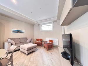 a living room with a couch and a tv at Homeby, Modern Loft Pisa in Pisa +9 photos
