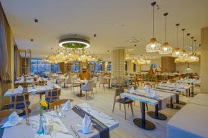 a restaurant with tables and chairs and chandeliers at Aletris Deluxe Hotel & SPA in Side