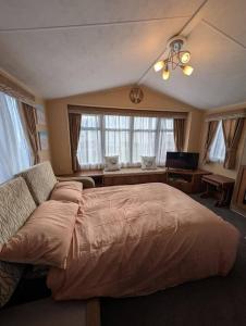 Un dormitorio con una cama grande y un sofá. en Camber Sands Holiday Park, en Camber 2 fotos más