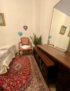 a bedroom with a dressing table and a chair and a mirror at Quintal do Bueno in Goiânia