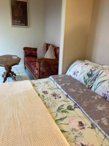 ChâtenetGite - Vin Rose的一间卧室，有两张床、一张沙发和一张桌子