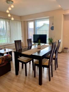 a dining room with a black table and chairs at Sunny Lotus Apartamentai in Druskininkai