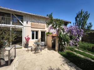 a patio with chairs and a table in front of a house at La Bastide Girondine in Saint-Loubès