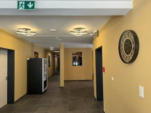 a hallway with yellow walls and a clock on the wall at Lillys Hotel 