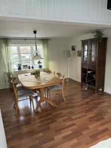 a dining room with a wooden table and chairs at Kvisthuset 1 Sal in Tylstrup