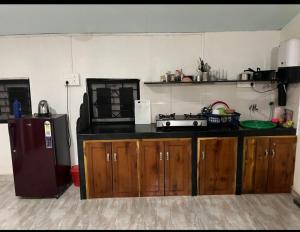 a kitchen with wooden cabinets and a black counter top at Tembewadda house in Canacona