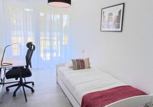 a bedroom with a bed and a desk and a chair at Luminous 2-Bed Apartment with Spacious Terrace RSC70-GF in Nyon