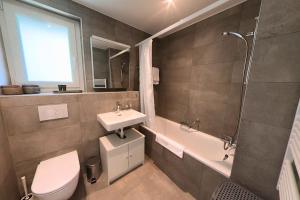 a bathroom with a sink and a toilet and a shower at Luminous 2-Bed Apartment with Spacious Terrace RSC70-GF in Nyon