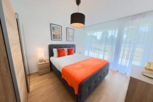 a bedroom with a large bed with an orange blanket at Luminous 2-Bed Apartment with Spacious Terrace RSC70-GF in Nyon