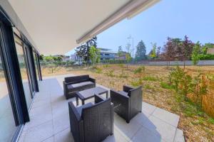 a patio with chairs and a table and a view of a field at Luminous 2-Bed Apartment with Spacious Terrace RSC70-GF in Nyon