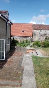 a house with a brick yard next to a building at Yew Tree Cottage in Bristol