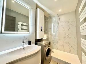 ein Badezimmer mit Waschbecken und Waschmaschine in der Unterkunft Appartement 3 chambres avec terrasse et Parking à Fréjus in Fréjus + 2 Fotos