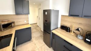 eine Küche mit Kühlschrank und Arbeitsplatte in der Unterkunft Appartement 3 chambres avec terrasse et Parking à Fréjus in Fréjus