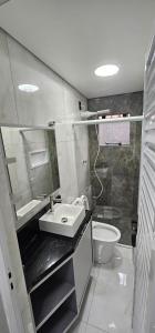 een badkamer met een wastafel, een toilet en een douche bij Kitnet Cic in Curitiba