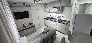 een woonkamer met een bank en een keuken bij Kitnet Cic in Curitiba